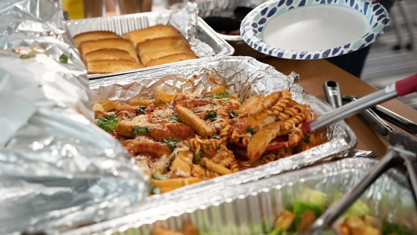 Hot Italian catering trays of pasta and pizza packed and ready for same-day delivery